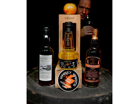 der Whisky 'Verbotener Apfel' mit Gregors Gesicht und Whiskyglas im dunklen Hintergrund