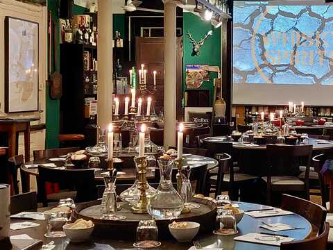 Unser Tastingraum mit runden Tischen und Projektion