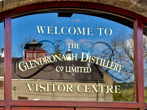 Im Fenster des Visitor Centre von Glendronach sich spiegelnde Destillery