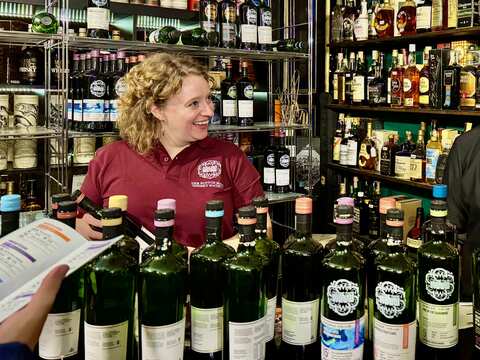 viele SMWS Flaschen vor Mitarbeiterin
