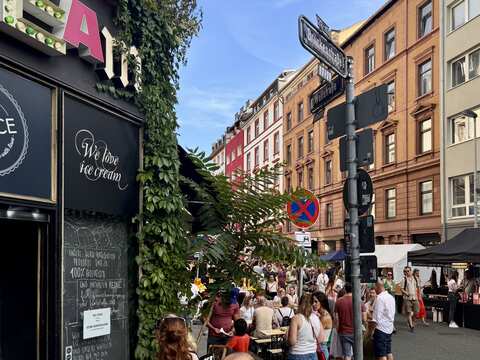 Menschen und Stände hinter dem Brückenstrassenschild